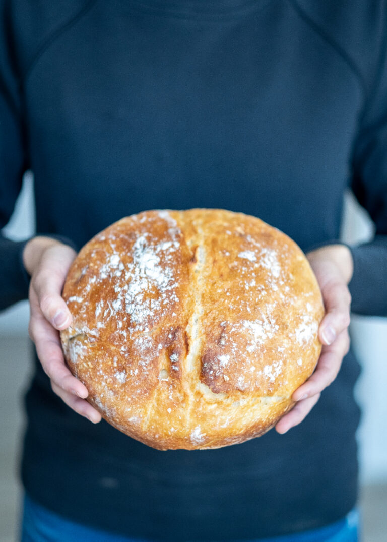Пекарь держит свежий хлеб